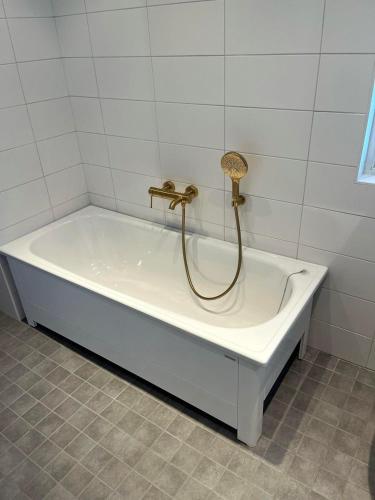 a bath tub with a shower in a bathroom at Exclusive villa with a stunning view in Sigtuna
