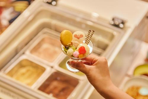 a person holding a glass filled with food at Hana Beppu in Beppu