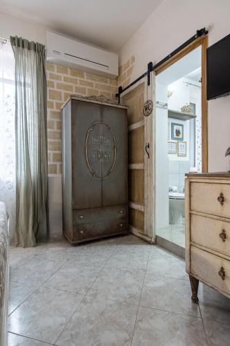 a bedroom with a dresser and a large wooden door at Grotta dei Puntali B&B in Carini