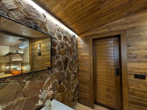a bathroom with a mirror and a stone wall at Casa Axier - Piscina Privada - Aire Acondicionado - Barbacoa in Biar