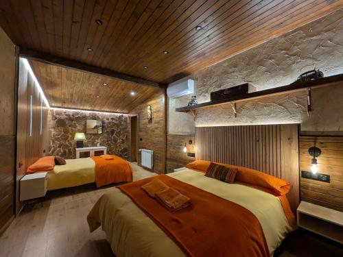 a bedroom with two beds and a stone wall at Casa Axier - Piscina Privada - Aire Acondicionado - Barbacoa in Biar