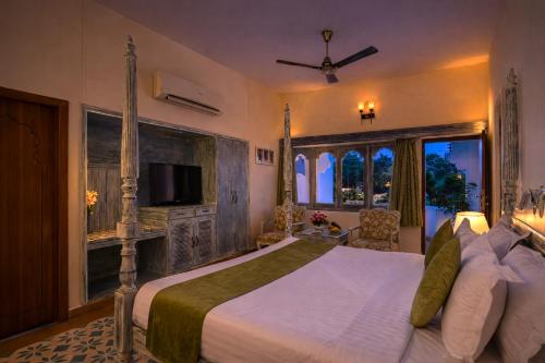a bedroom with a large bed and a large window at Swaroop Vilas - Lake Facing Boutique Hotel in Udaipur