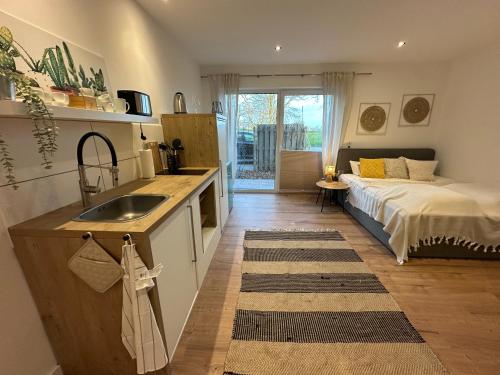 a kitchen with a sink and a bed in a room at Deich Quartier 9.2 in Dorum-Neufeld