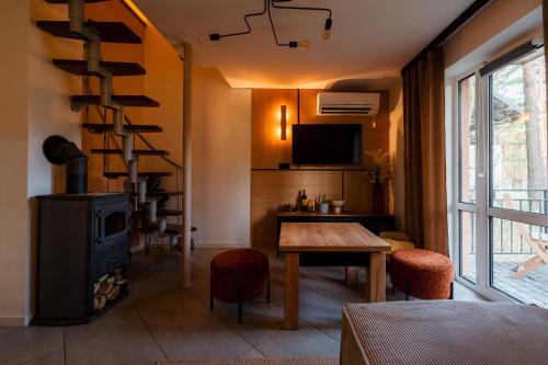 a living room with a wood stove and a table at Kajaki wino i śpiew - domek z sauną w otoczeniu lasów i sąsiedztwie zalewu in Zakrzówek Szlachecki