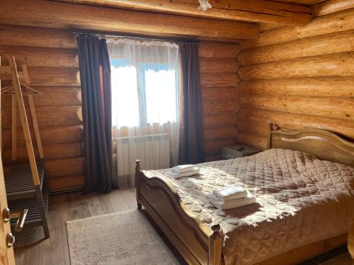 a bedroom with a bed in a log cabin at Смерековий двір in Polyana