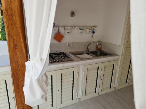 a kitchen with a sink and a stove at Casa Bruna in San Teodoro