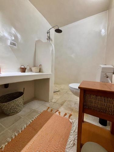 a bathroom with a white toilet and a sink at Hoûch Les Anartistes in Erriadh