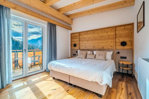 a bedroom with a bed and a large window at Hotel Bel Sit Spa in Valle di Cadore