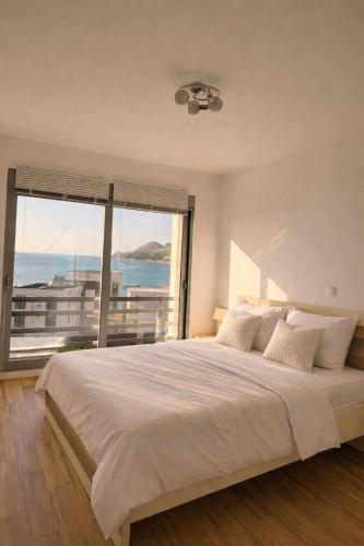 a bedroom with a large bed with a large window at Sunrise apartmani in Bar