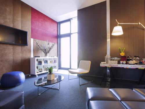 ein Wohnzimmer mit Sofa und Tisch in der Unterkunft Ibis Styles Roma Eur in Rom