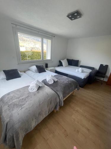 a bedroom with two beds and a window at Le rocher in Sierre