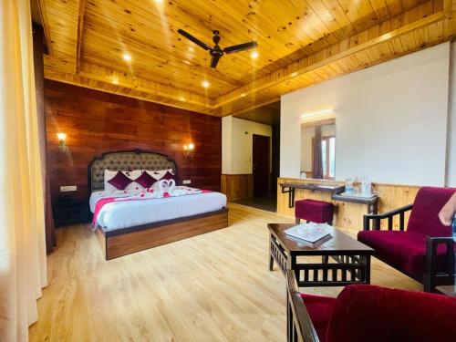 a bedroom with a bed and a couch and a table at Royal Ocean COTTAGE in Manāli