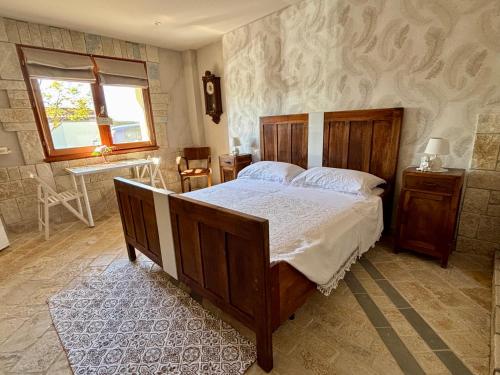 a bedroom with a large wooden bed and a window at Affittacamere Agli Ulivi in Gemona del Friuli