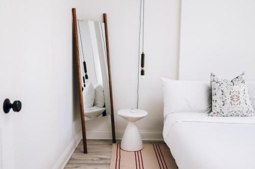 a bedroom with a white bed and a mirror at The Neighborhood Hotel - Lincoln Park 501 - Three Bedroom Penthouse in Chicago