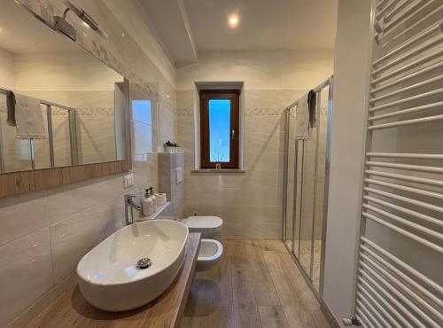 a white bathroom with a sink and a toilet at Affittacamere Agli Ulivi in Gemona del Friuli