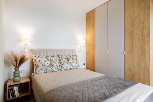 a bedroom with a bed with a wooden headboard at Apartament Harmonia Baltic in Sarbinowo