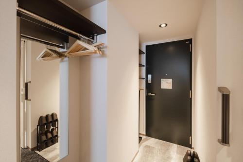 a hallway with a black door in a room at Hotel SHUTEC in Kagoshima