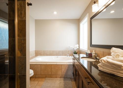 a bathroom with a tub and a toilet and a sink at Modern comfort in Lethbridge