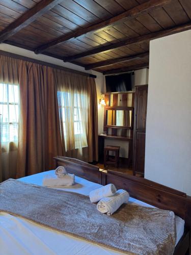 a bedroom with a bed with two towels on it at Poarta 1 in Portaria