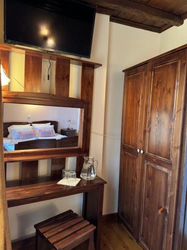 a room with a bed and a wooden cabinet at Poarta 1 in Portaria