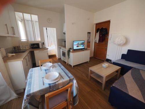 a small living room with a table and a kitchen at Le Picaflor YourHostHelper in Hyères