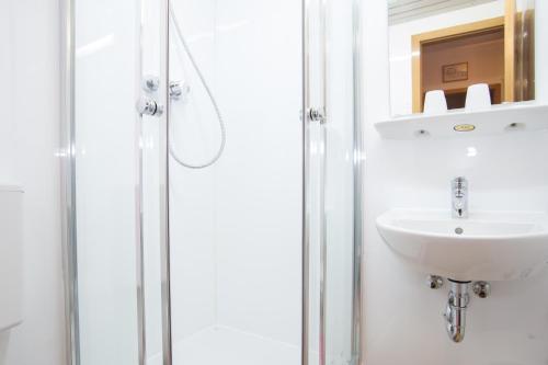 a bathroom with a sink and a shower at Hotel Moosbichl in Munich