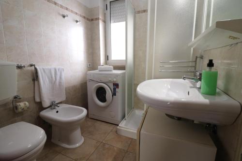 a bathroom with a toilet sink and a washing machine at Ayra's House Otranto in Otranto