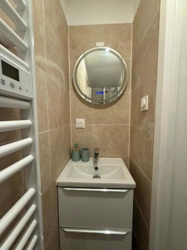 a small bathroom with a sink and a mirror at Le Petit Coin in Saintes