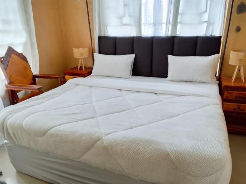 a large white bed in a room with a window at Dewclaw Baobab Safari Lodge in Mfuwe