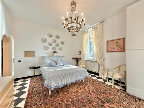 a bedroom with a bed and a chandelier at VILLA NORMA in Levanto