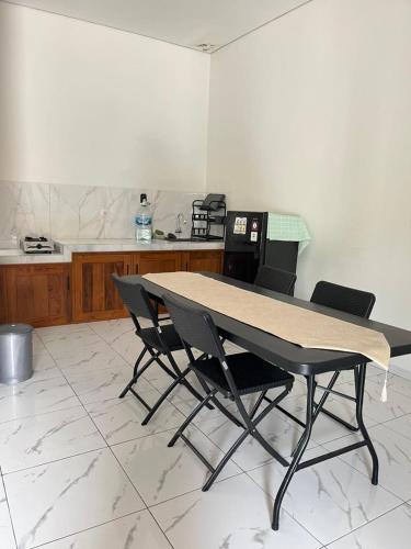 a table and four chairs in a kitchen at D & R House Syariah in Jagalan