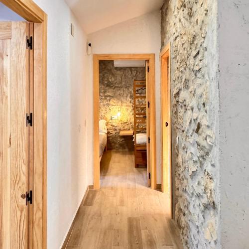 a hallway leading to a room with a stone wall at Villa Jimena in Periana