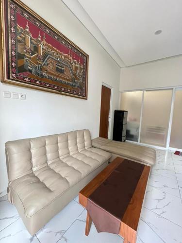 a living room with a white couch and a table at D & R House Syariah in Jagalan