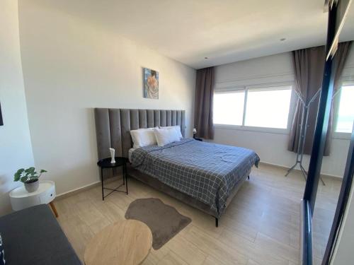 a bedroom with a bed and a large window at Estrella de Martil in Martil