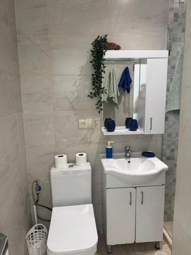 a white bathroom with a toilet and a sink at Estrella de Martil in Martil