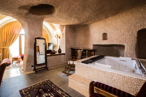 a large living room with a large tub in a room at CCR Cappadocia Cave Resort &Spa in Eskiömerler