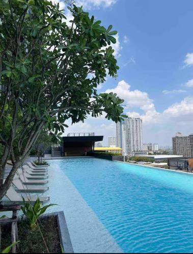 a swimming pool with trees and buildings in the background at ริเวอร์วิวแม่น้ำเจ้าพระยา62ชั้น in Ban Sai Ma