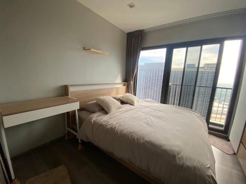 a bedroom with a bed and a large window at ริเวอร์วิวแม่น้ำเจ้าพระยา62ชั้น in Ban Sai Ma