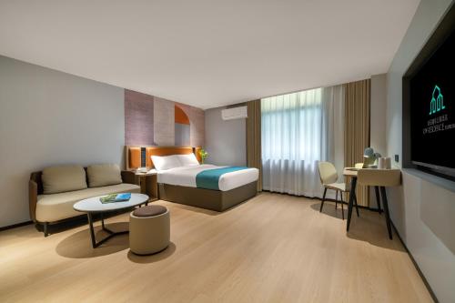 a hotel room with a bed and a couch at Guang Dong Hotel in Guangzhou
