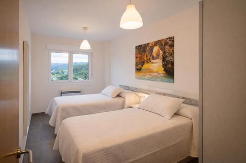 a room with two beds and a painting on the wall at Nova MSuites Xove in Lago