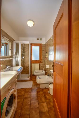 a bathroom with two sinks and a tub and a toilet at Appartamenti Leovacanze in Auronzo di Cadore
