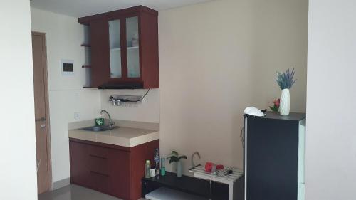 a small kitchen with a sink and a refrigerator at Prestige Living at B Residence BSD in Serpong