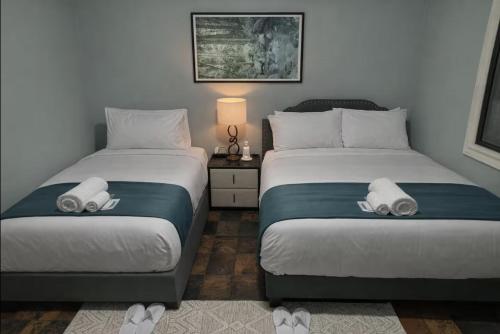 a bedroom with two beds with slippers on them at The Haven House in Singleton