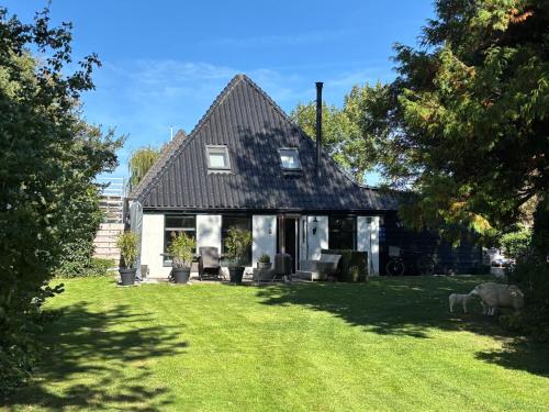 a house with two sheep standing in the yard at Slapen@Boet1619 Andijk in Andijk