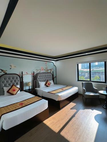 a bedroom with two beds and a chair and a window at Sunrise Villa Hanoi in Hanoi