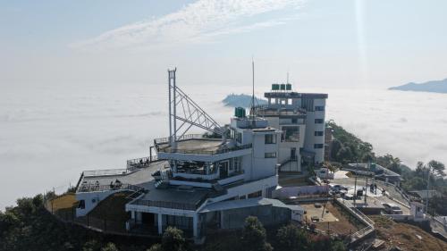a building on top of a mountain in the clouds at Pokhara Heights Resort Pvt Ltd in Pokhara