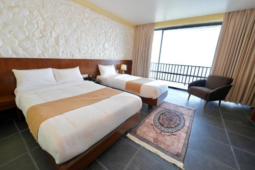 a hotel room with two beds and a balcony at Pokhara Heights Resort Pvt Ltd in Pokhara