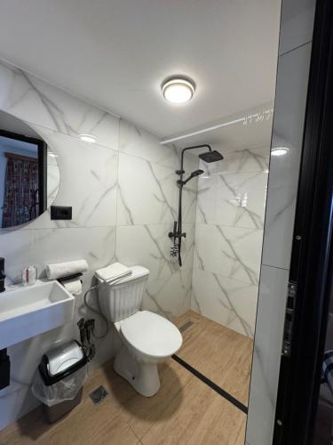 a bathroom with a toilet and a sink and a shower at Elti Apartment in Sarandë