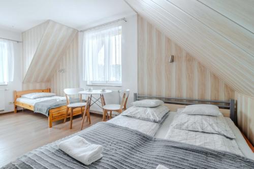 a bedroom with two beds and a table with chairs at Willa Danielski in Niedzica