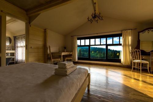 a bedroom with a bed and a large window at The Provence Village in Bukovinka